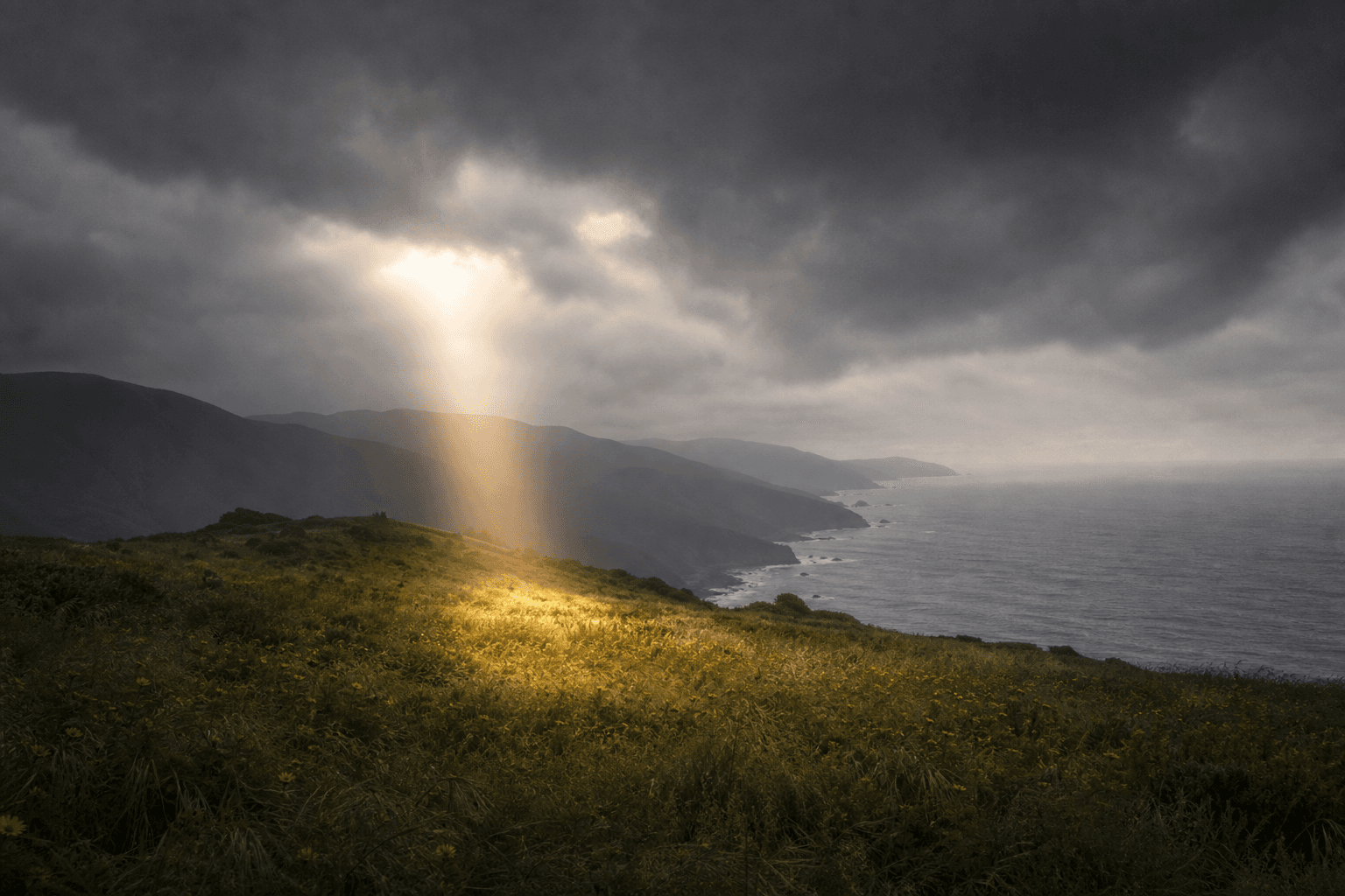 Single shaft of warm light breaking through grey clouds over a California hillside representing hope in depression treatment